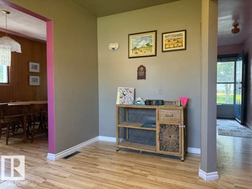 Wood-finish flooring throughout, featuring a neutral wall color with accent trim - 9908 96A Avenue, Fort Saskatchewan, AB - Indoor Photo Showing Other Room