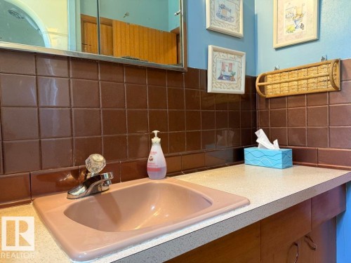 Built-in vanity with an integrated sink, polished chrome faucet, and spacious countertop - 9908 96A Avenue, Fort Saskatchewan, AB - Indoor Photo Showing Bathroom