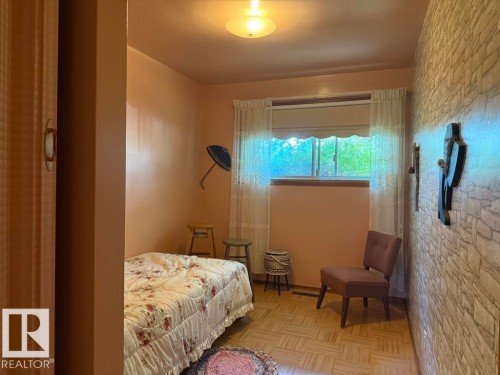 Hardwood parquet flooring with a window featuring sheer curtains and a valance - 9908 96A Avenue, Fort Saskatchewan, AB - Indoor Photo Showing Bedroom