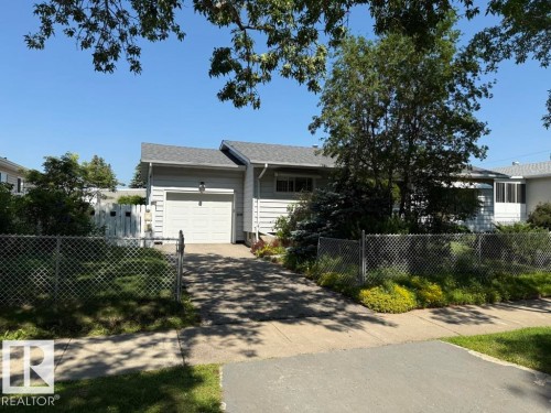 Ranch-style residence featuring a single-car garage, asphalt shingle roof, and light-colored siding - 9908 96A Avenue, Fort Saskatchewan, AB - Outdoor