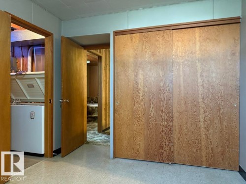 Full-height wardrobe with wood-finish sliding doors - 9908 96A Avenue, Fort Saskatchewan, AB - Indoor Photo Showing Laundry Room