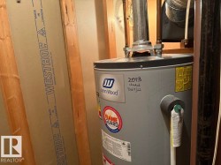 Utility space featuring a John Wood water heater and visible wall framing with Westroc gypsum board - 