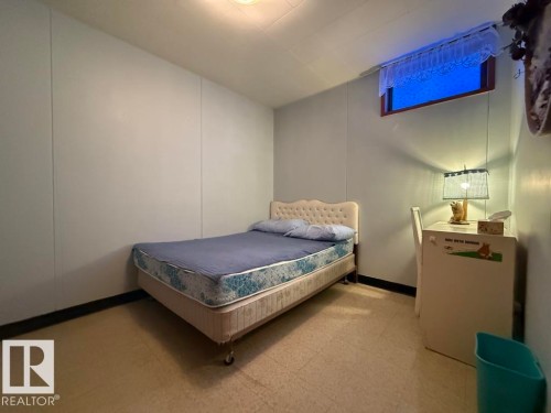 Room featuring panel wall finishes, a single window, and light-colored flooring - 9908 96A Avenue, Fort Saskatchewan, AB - Indoor Photo Showing Bedroom