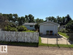 Detached garage with a roll-up door and concrete driveway - 