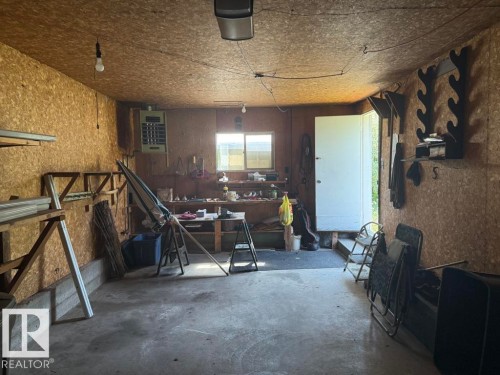 Concrete floor garage with oriented strand board walls and ceiling - 9908 96A Avenue, Fort Saskatchewan, AB - Indoor Photo Showing Other Room