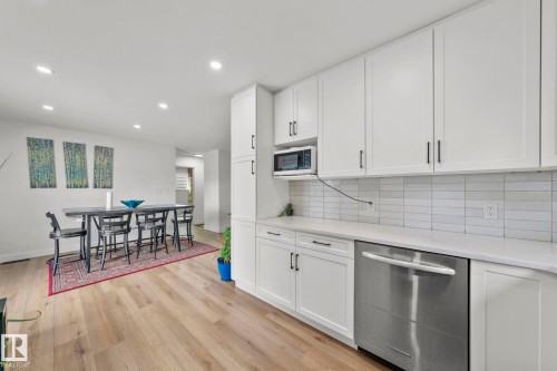 Contemporary kitchen featuring white cabinetry, a white subway tile backsplash, and light-tone wood-finish flooring - 4119 18 Avenue Nw, Edmonton, AB - Indoor Photo Showing Kitchen