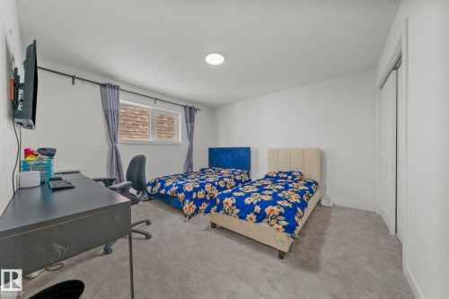 Carpeted interior room with white walls, a single window featuring horizontal blinds, and a built-in closet with bi-fold doors - 4119 18 Avenue Nw, Edmonton, AB - Indoor