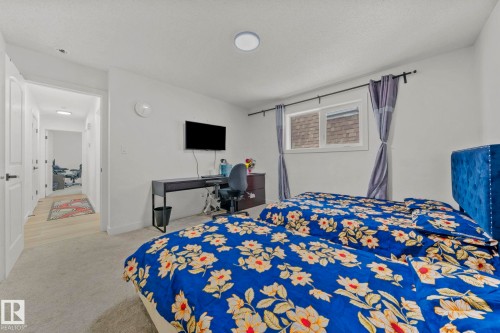 Spacious room featuring light gray carpeting, a single window with a privacy blind, and a recessed ceiling light fixture - 4119 18 Avenue Nw, Edmonton, AB - Indoor Photo Showing Bedroom
