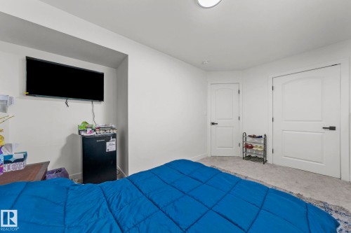 Carpeted interior space featuring two white panel doors with matte black hardware - 4119 18 Avenue Nw, Edmonton, AB - Indoor Photo Showing Bedroom