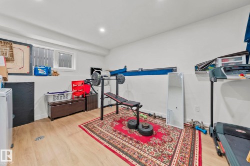 Finished basement space featuring light wood-finish flooring and white painted walls - 4119 18 Avenue Nw, Edmonton, AB - Indoor