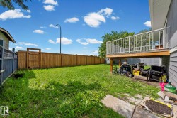 Expansive grass lawn featuring a wood privacy fence with a gate - 