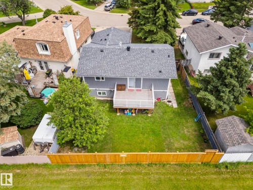 Private backyard featuring a wooden deck, mature trees, a wooden privacy fence, and a storage shed - 4119 18 Avenue Nw, Edmonton, AB - Outdoor