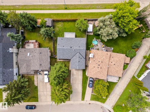 Residential property featuring a grey shingle roof, two paved driveways, a spacious grass lawn, and mature perimeter trees - 4119 18 Avenue Nw, Edmonton, AB - Outdoor With View