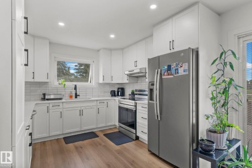 Kitchen featuring white shaker cabinetry, stainless steel appliances, a subway tile backsplash, recessed lighting, and wood-finish flooring - 4119 18 Avenue Nw, Edmonton, AB - Indoor Photo Showing Kitchen