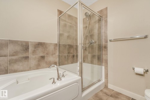 Integrated white tub and glass-enclosed shower with chrome fixtures - #16 7293 South Terwillegar Dr Nw, Edmonton, AB - Indoor Photo Showing Bathroom