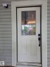 White paneled entry door featuring a decorative glass insert - 10656 93 Street, Edmonton, AB 