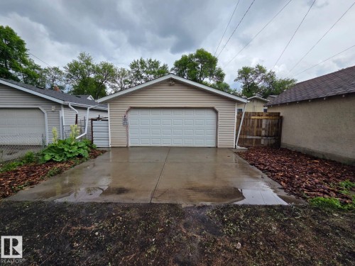 Detached garage featuring panel siding and a sectional overhead door - 10656 93 Street, Edmonton, AB 