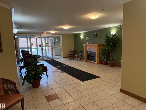 Spacious entryway featuring tile flooring with decorative accents - #302 8215 84 Av Nw, Edmonton, AB - Indoor Photo Showing Other Room