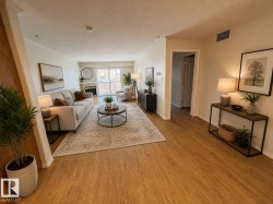 Open-concept living space featuring wood-finish flooring, a built-in fireplace, crown molding, and sliding glass doors - 