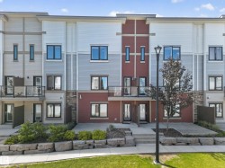 Modern townhome exterior featuring multi-toned siding, dark-framed windows, and a flat roofline - 