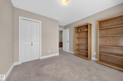 Neutral-toned room featuring a light brown carpet, white baseboards, and a white ceiling with a flush-mount light fixture - 