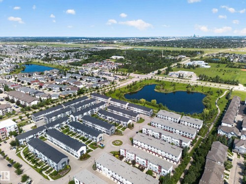 Aerial perspective showcasing a modern townhome community with uniform architecture and dark-pitched roofs - #100 804 Welsh Dr Sw, Edmonton, AB - Outdoor With View