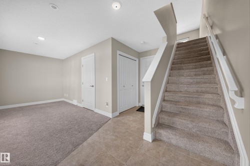 Carpeted staircase with white balusters - #100 804 Welsh Dr Sw, Edmonton, AB - Indoor Photo Showing Other Room