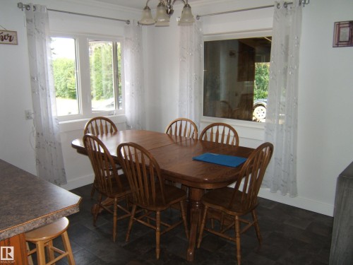 Bright dining area featuring dark wood-finish flooring, white walls, and crown molding - 151042 Twp  Rd 562, Rural Two Hills County, AB - Indoor Photo Showing Dining Room
