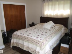 Bedroom featuring wood-finish flooring and a closet with bifold doors - 