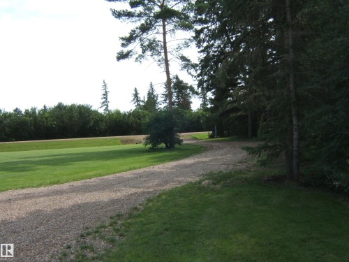 Extensive gravel driveway bordered by lush green lawns - 151042 Twp  Rd 562, Rural Two Hills County, AB - Outdoor