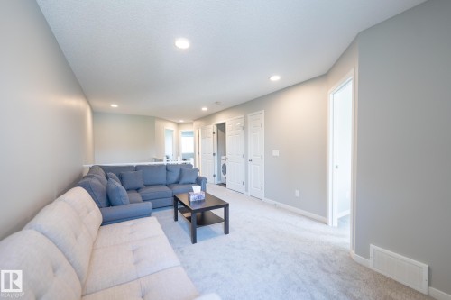 Carpeted loft area featuring recessed lighting, a half-wall railing, and multiple white paneled doors - 5403 Lark Landing Nw, Edmonton, AB - Indoor Photo Showing Living Room