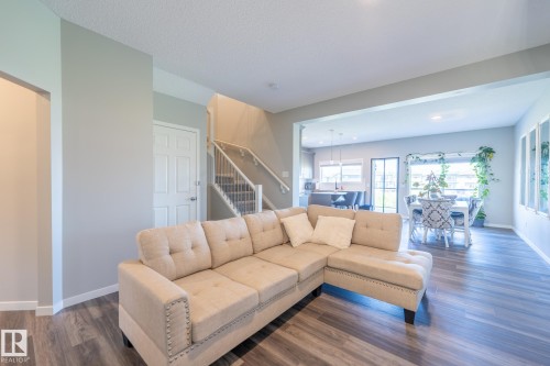 Open-concept living space featuring wood-finish flooring, a neutral color palette, and recessed lighting - 5403 Lark Landing Nw, Edmonton, AB - Indoor Photo Showing Living Room