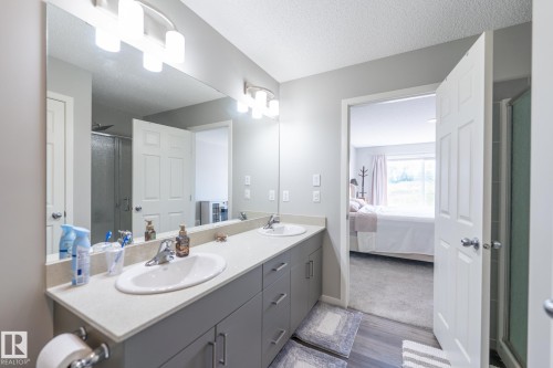Double vanity with gray cabinetry, light-colored countertops, and chrome fixtures - 5403 Lark Landing Nw, Edmonton, AB - Indoor Photo Showing Bathroom