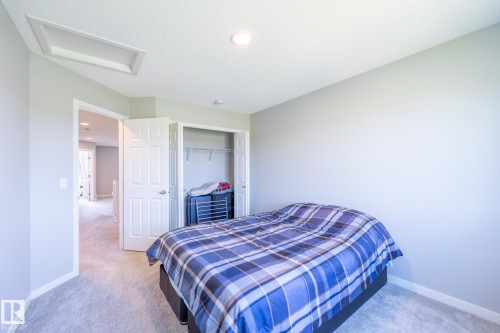 Carpeted room with light gray walls, white trim, and a white six-panel door - 5403 Lark Landing Nw, Edmonton, AB - Indoor Photo Showing Bedroom