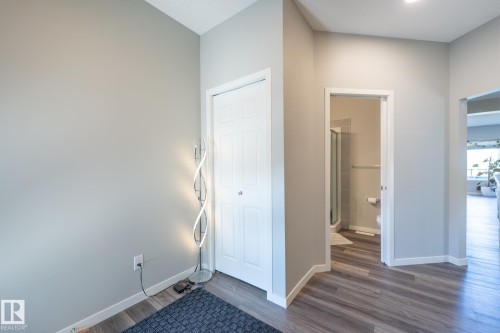 Hallway featuring wood-finish flooring, light gray walls, and white trim - 5403 Lark Landing Nw, Edmonton, AB - Indoor Photo Showing Other Room
