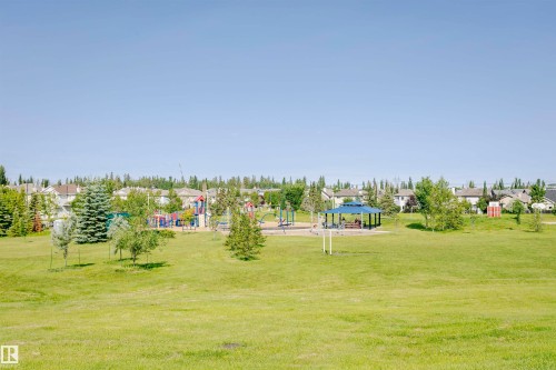Green space featuring a playground, open field, and covered picnic structure - #205 226 Macewan Rd Sw, Edmonton, AB - Outdoor With View