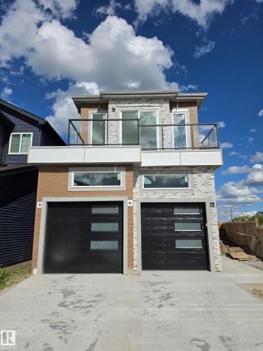 Contemporary duplex exterior featuring a combination of horizontal siding and stone veneer accents - 231 28 Street Sw, Edmonton, AB - Outdoor