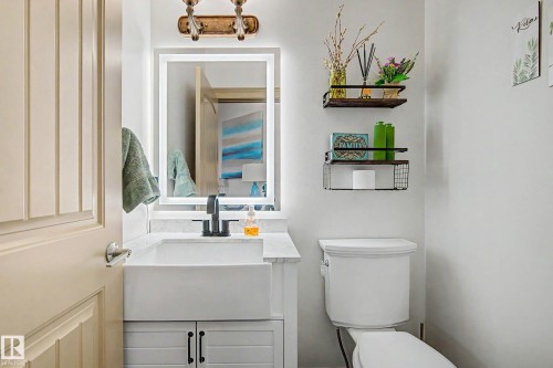 Modern bathroom featuring a white farmhouse-style sink, quartz countertop, and black matte faucet - 38 Longview Point(E), Spruce Grove, AB - Indoor Photo Showing Bathroom
