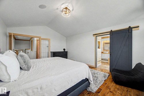 Bedroom featuring wood-finish flooring and a vaulted ceiling with an overhead light fixture - 38 Longview Point(E), Spruce Grove, AB - Indoor Photo Showing Bedroom