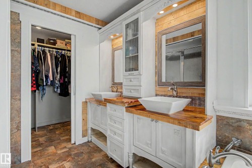 Bathroom featuring dual vessel sinks, wood-finish countertops, and white cabinetry - 38 Longview Point(E), Spruce Grove, AB - Indoor Photo Showing Bathroom