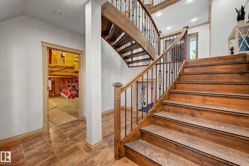 Grand staircase featuring wood treads, wrought iron balusters, and a rich wood handrail - 38 Longview Point(E), Spruce Grove, AB - Indoor Photo Showing Other Room
