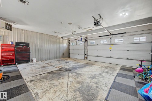 Spacious garage featuring two overhead doors with window inserts and automatic openers - 38 Longview Point(E), Spruce Grove, AB - Indoor Photo Showing Garage