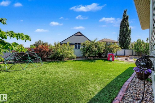 Expansive green lawn with established perimeter landscaping and a border of brick pavers and decorative rock - 38 Longview Point(E), Spruce Grove, AB - Outdoor