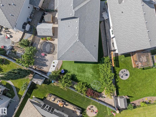 Expansive backyard featuring a manicured lawn, mature trees, and a concrete patio - 38 Longview Point(E), Spruce Grove, AB - Outdoor With View