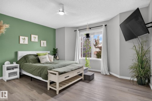 Bedroom featuring a distinct accent wall and wood-finish flooring - 833 Mcallister Crescent Sw, Edmonton, AB - Indoor Photo Showing Bedroom