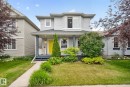 Two-story residence featuring light gray siding, a covered front porch with white railing, and a vibrant yellow front door - 833 Mcallister Crescent Sw, Edmonton, AB  - Outdoor With Deck Patio Veranda With Facade 