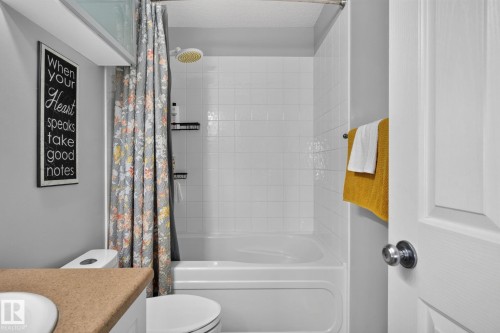 Bathroom featuring a white tub/shower combination with white tile surround - 833 Mcallister Crescent Sw, Edmonton, AB - Indoor Photo Showing Bathroom