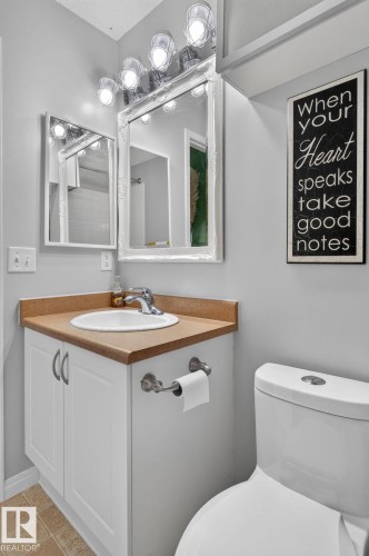 Bathroom vanity featuring a white cabinet base, light brown countertop, and an integrated white sink - 833 Mcallister Crescent Sw, Edmonton, AB - Indoor Photo Showing Bathroom