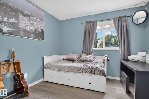 Room featuring wood-finish flooring, a white window frame, and a built-in daybed with storage drawers - 833 Mcallister Crescent Sw, Edmonton, AB - Indoor Photo Showing Bedroom