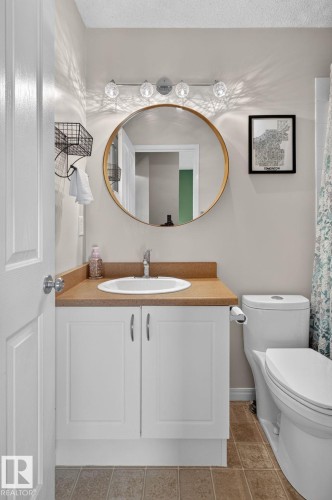 Bathroom featuring a white vanity with double cabinet doors, a drop-in sink, and a tan countertop - 833 Mcallister Crescent Sw, Edmonton, AB - Indoor Photo Showing Bathroom